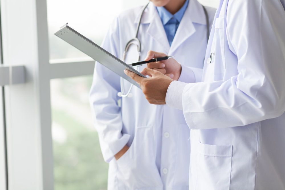 Two doctors consult over a patient's chart